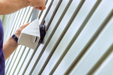 Dış duvarda havalandırma için evrensel bir kapak havalandırma vantilatörü kuruluyor.