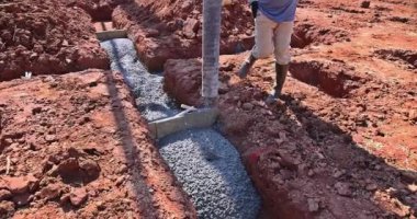 İnşaat alanında çalışan işçilerin beton karışımı dökülen yeni ev temeli