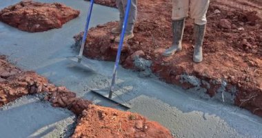 İnşaat işçisi temele beton döküyor.