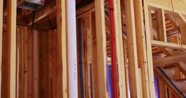 労働者は新しい家のプラスターボードの前に絶縁材 配管システム 電気ワイヤーおよび天井ライトを取付けます — ストック動画