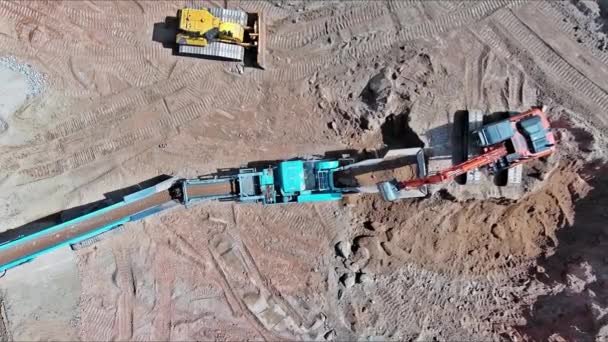 粉砕された円錐形岩粉砕機を処理し 採石場の開いたピット鉱山で花崗岩の砂利石を運ぶ — ストック動画