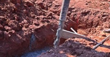 İnşaat alanındaki yeni ev için beton karışımı döken işçiler