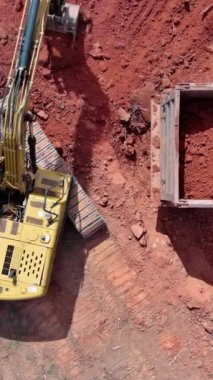 İnşaat alanı, kazıcı kullanan işçiler toprağı çöp kamyonuna yüklüyor, inşa edilen ev için hazırlık alanı