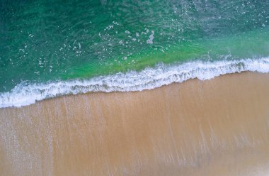 Kumlu sahillere düşen dalgaların, kumsaldaki yüzey dalgalarının havadan görüntüsü.