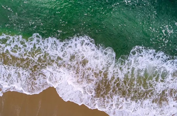 Sahile vuran dalgalarla sahili, kumsala vuran dalgaların havadan görüntüsü.