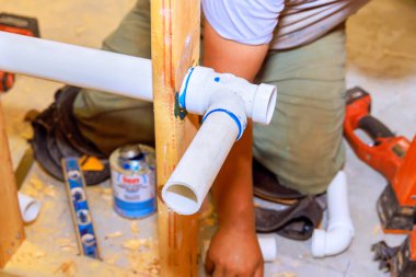 Yeni ev yapımı tesisatçı duvarda drenaj sistemi kuruyor. Yeni bir ev.