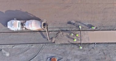 Beton kaldırım yolu inşaat şirketinin çalışanları tarafından ıslak beton dökerek inşa ediliyor.