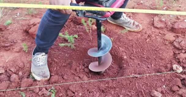 Trabajador Cava Terreno Para Postes Esgrima Utilizando Máquina Perforación Gasolina — Vídeos de Stock