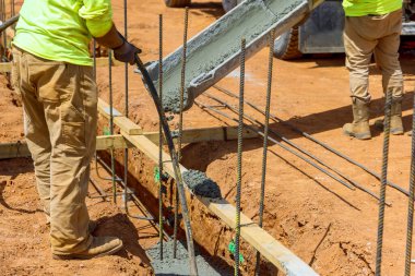 İnşaat alanındaki işçilerin yeni ev temeli için beton karışımı dökülüyor