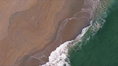 Kumlu sahile vuran dalgaların havadan görüntüsü, yüzey okyanus dalgaları plajı.