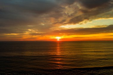 Sabahın erken saatlerinde, güneş dalgaların üzerinde yükselir.