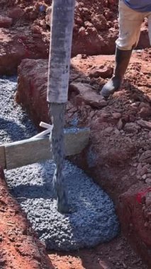İnşaat alanında çalışan işçiler etrafa beton dökerek yeni ev temellerini oluşturuyorlar.