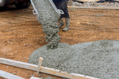 Yeni evin garaj yolu için beton karıştırma kamyonu kullanan işçiler tarafından beton döküldü.