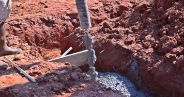 İnşaat işçisi yeni ev için beton döktü.