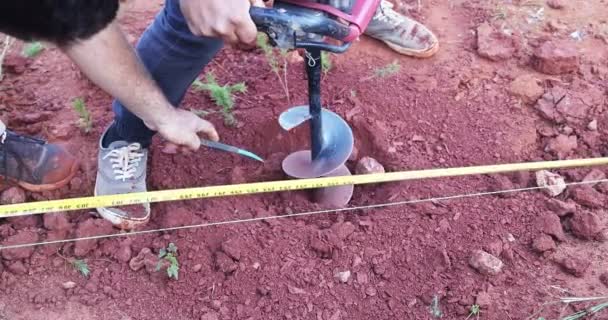 Καθώς Φράγματα Θάβονται Εργάτης Χρησιμοποιεί Τρυπάνι Βενζίνης Για Σκάψει Έδαφος — Αρχείο Βίντεο