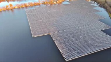 Suda yüzen bir dizi güneş paneli. Güneş ışığından elektrik üreten büyük bir gölet.