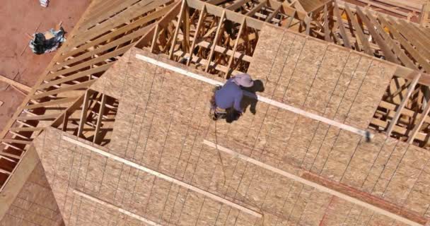 建筑工人在未来住房的屋顶上把钉子钉在胶合板上 — 图库视频影像