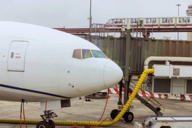 Yolcu uçağı, bir sonraki kalkıştan önce havaalanındaki biniş kapısı köprüsünde yer hizmetleri tarafından hizmet vermektedir.