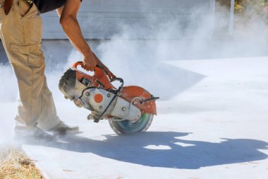 Precise Concrete Paving Sidewalk Removal by Construction Worker Using Diamond Blade Saw clipart