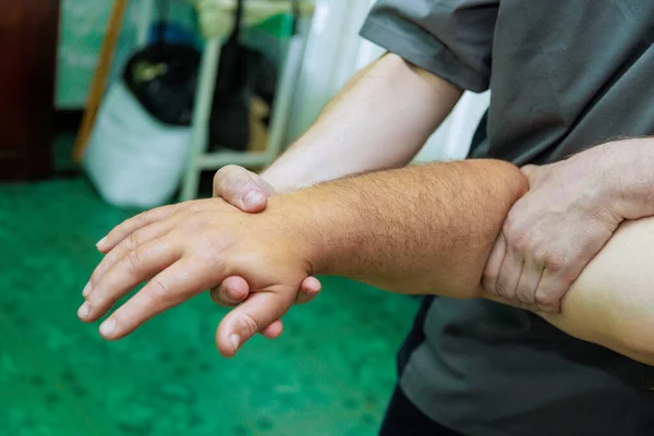 Masseuse makes hand massages for man using traditional hand massage techniques