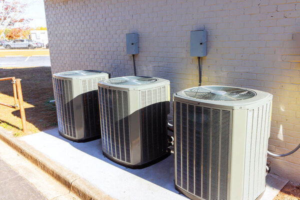An outdoor air conditioning units has been installed on exterior facade of new house