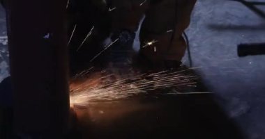 Demir işçisi öğütücü bir disk işleme kıvılcımı kullanarak metali keser