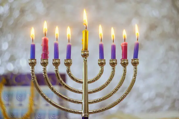 An important Hanukkah Jewish holiday symbol is Hanukkiah Menorah lit by candles