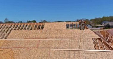 Marangoz inşaat işçileri gelecekteki yeni evin çatısına çivi çakıyorlar.