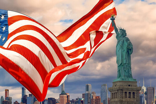 Featuring Statue of Liberty is beautifully waving American flag with Manhattan at New York City background