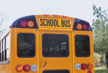 Turuncu bir okul otobüsü banliyö uyku bölgesinde cadde boyunca gider.