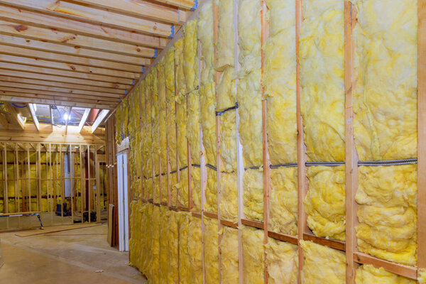 Thermal fiberglass insulation mineral rock wool installation to wall at new construction home