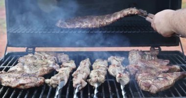 BBQ ızgarasının üzerinde leziz domuz etleri tüttürülüyor hazırlık için.