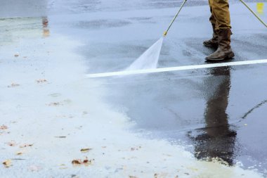Basınçlı su kullanarak sokağın temizlenmesi ıslak bir çamaşır.