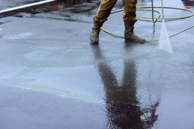 Temiz sokağa basınçlı su sıkılmış, ıslak çamaşır yıkama.