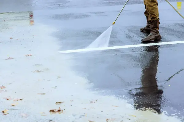 stock image Cleanup of street using pressurized water a wet washing