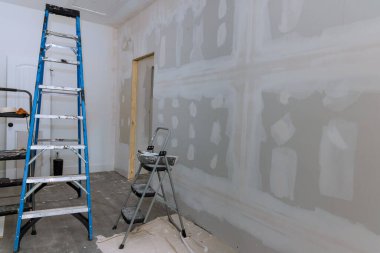 Plastering drywall is complete ready for painting in new house that is under construction clipart