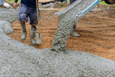 Beton karıştırma kamyonu yeni evin garaj yolu için ıslak çimento dökmek için kullanıldı.