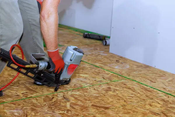 Use of an air nail gun to install wooden plywood for floor coverings in new home
