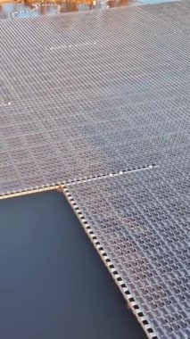 Suda yüzen bir dizi güneş paneli. Güneş ışığından elektrik üreten büyük bir gölet.