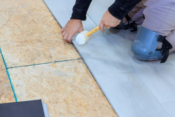 Man installing laminate flooring panel at new home