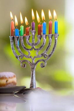 Bayram dini sembolü Hanuka Menorah, Hanukkiah mumlarıyla aydınlatılmış.