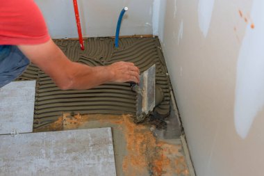Döşeme fayanslarının döşemesi için beton zemine troweling yapıştırıcısı gerekiyor..