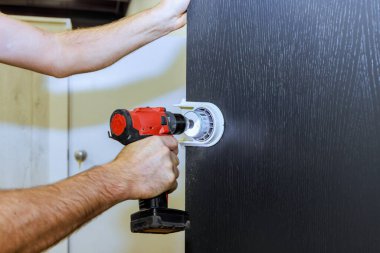 Ahşap kapılarda kilit tutacakları için delik açan usta.