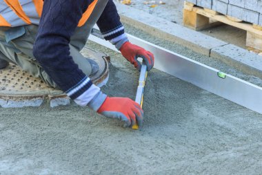 Yaya yolu için dekoratif taş yerleştirmeden önce kum düzleştiriliyor