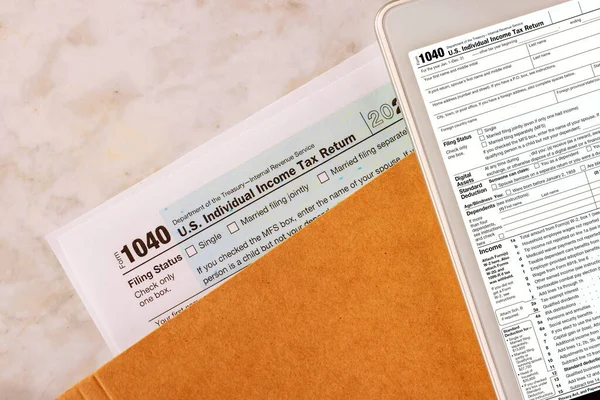 Filing online on digital tablet with individual income tax form 1040 is prepared by accounting office during tax season