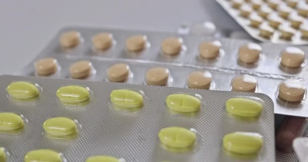 単離された白い背景には さまざまな薬剤ブリスターがあり それぞれカラフルな錠剤 カプセルが異なる混合物を保持しています — ストック動画