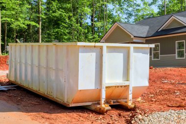 İnşaat alanında, hurda atıklarını depolamak için metal konteynırlar var.