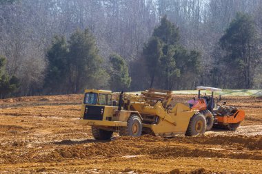 Altyapı kurulumuna hazırlanmak için inşaat alanında ağır ekipmanların çalıştığı açık.