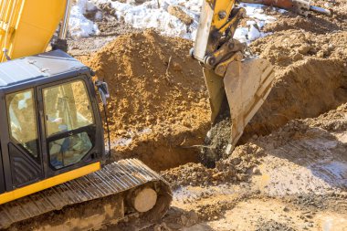 Altyapı alanını hazırlamak için inşaat sahasındaki toprak taşıma operasyonlarının bir parçası olarak bir kazıcı tarafından kazılıyor.
