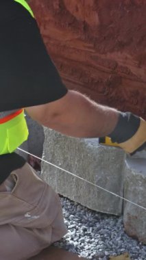 İnşaat alanındaki duvarların yıkılışından sonra duvar inşaatçıları beton blok döşedi. dikey video
